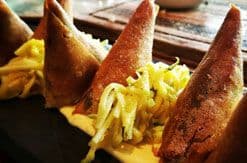 Ice cream cones filled with yellow soft-serve ice cream arranged on a dark surface